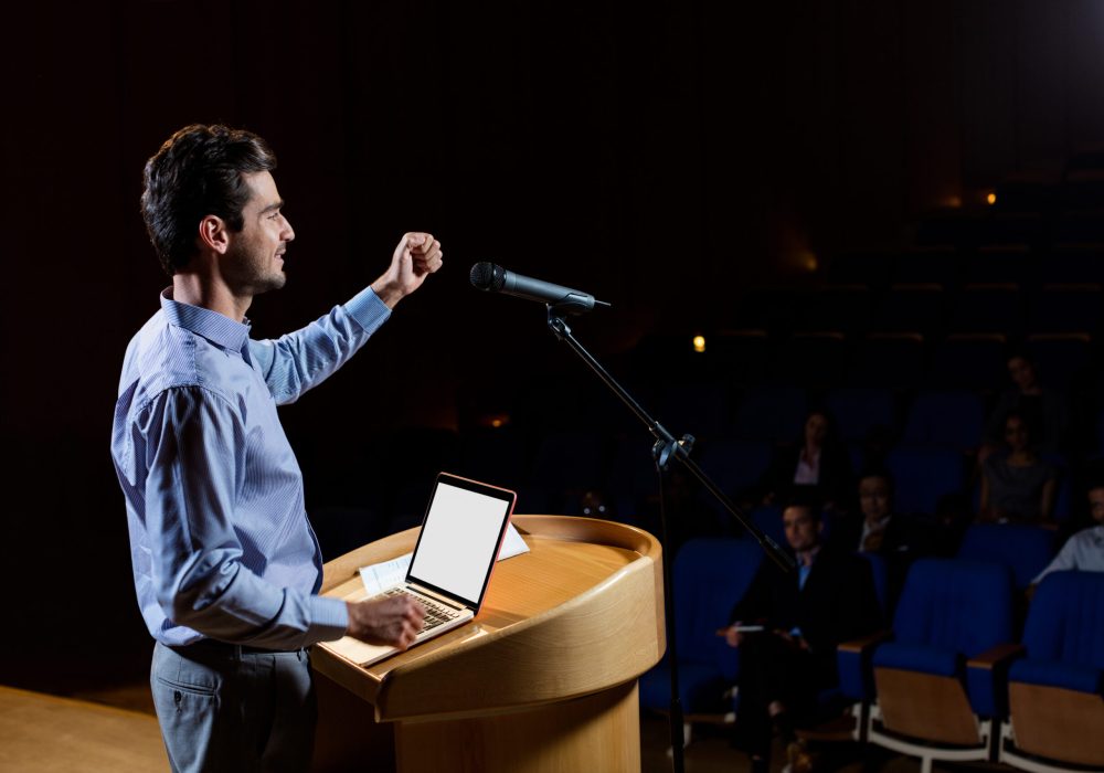 Male business executive giving a speech at conference center